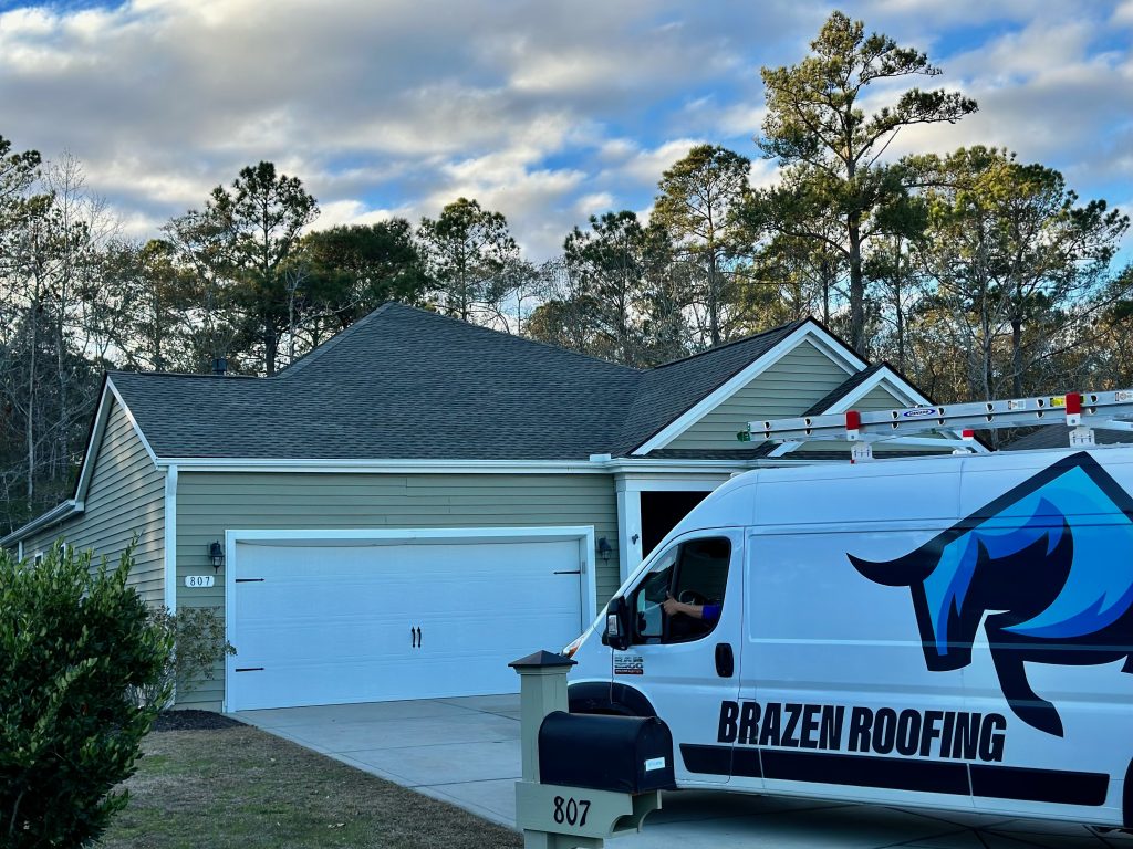 IMG_9144 Close-up of a two-car garage roofline with a Brazen Roofing service van parked in the driveway in Myrtle Beach, SC