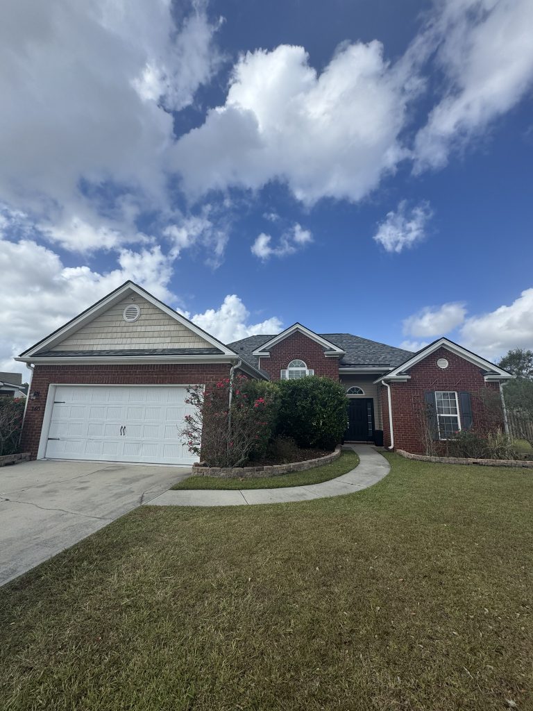 item_62cfbda1-a16a-4ad3-8dbc-da103aaac4be Brick single-story home with a round window accent and new dark shingle roof in Savannah, GA