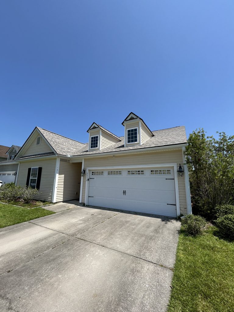 Single-story beige home with dormer windows and a newly installed shingle roof in Charleston, SC