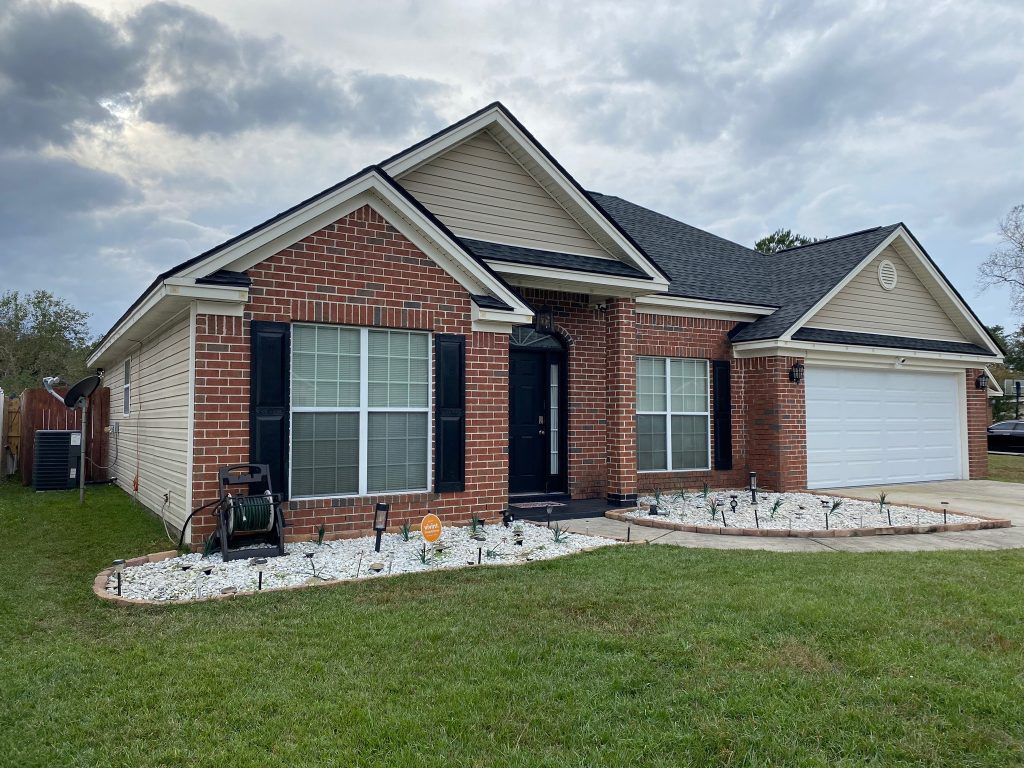item_7183e411-648c-4a1d-85bf-b18eb9cf9a0c Single-story tan home with a two-car garage and freshly installed shingle roof in Savannah, GA