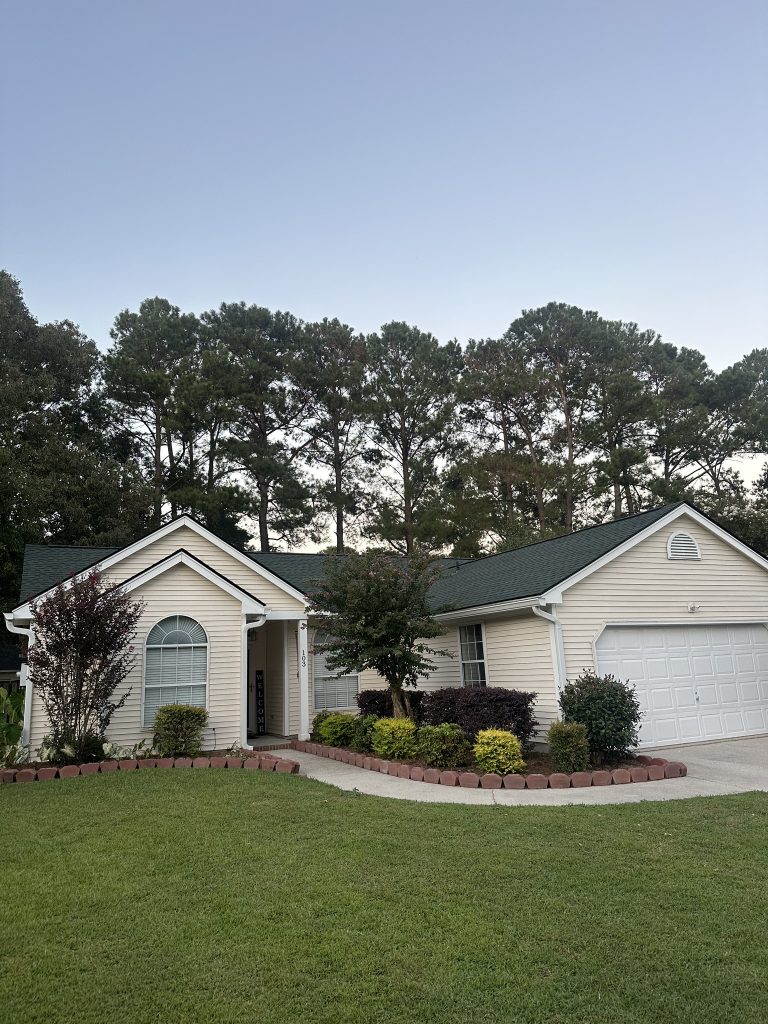 Two-story home with white trim and a freshly installed dark shingle roof in Charleston, SC