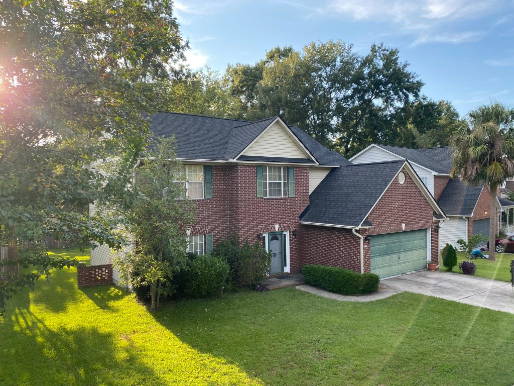 Two-story tan home with dormer windows and a newly installed shingle roof in Charleston, SC