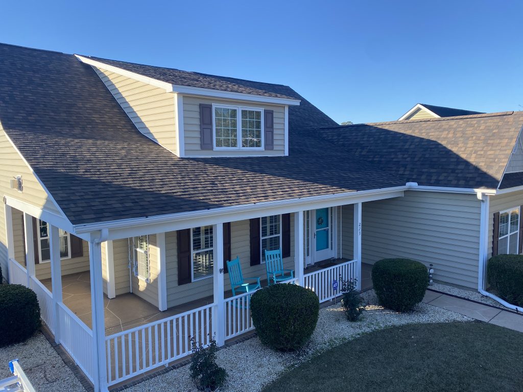 item_9d56d35d-8bef-433c-a5ae-1f7143998e6c Tan two-story home with a covered porch and new shingle roof in Myrtle Beach, SC
