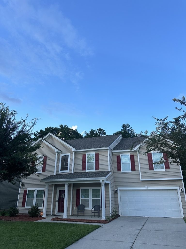 Aerial drone view of a residential roof replacement surrounded by trees in Charleston, SC
