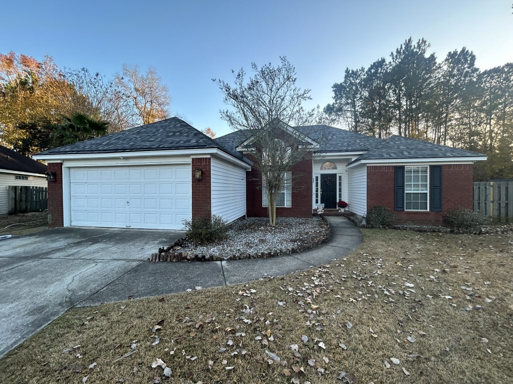 item_b85c9c07-4217-4cca-8256-7e4d52c32125 Brick and white ranch home with a new dark shingle roof surrounded by autumn trees in Savannah, GA