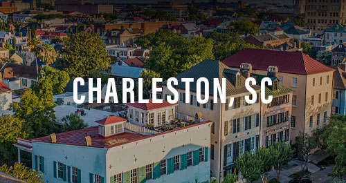 Aerial view of historic Charleston, SC rooftops and colorful downtown buildings at sunset