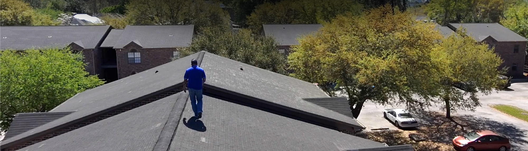 Brazen Roofing team member inspecting an apartment complex roof after hurricane damage in Myrtle Beach, SC